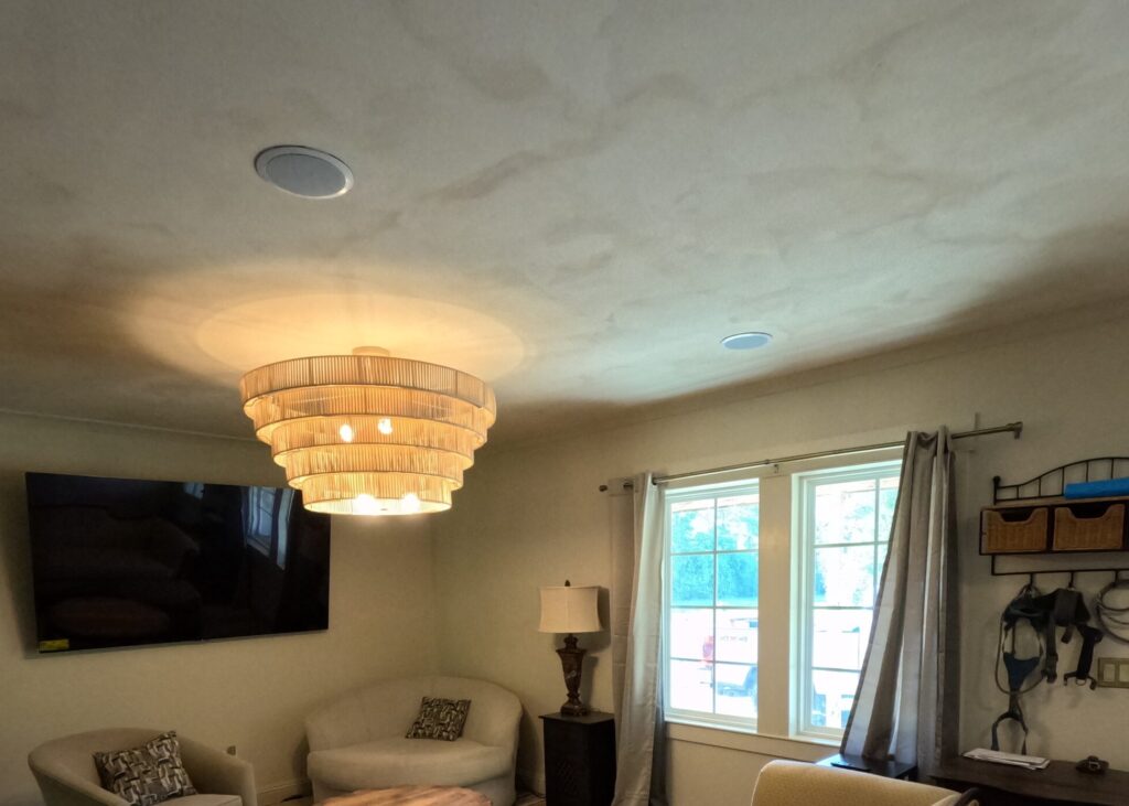 Limewash ceiling with a soft, mottled finish above a living room with a tiered pendant light