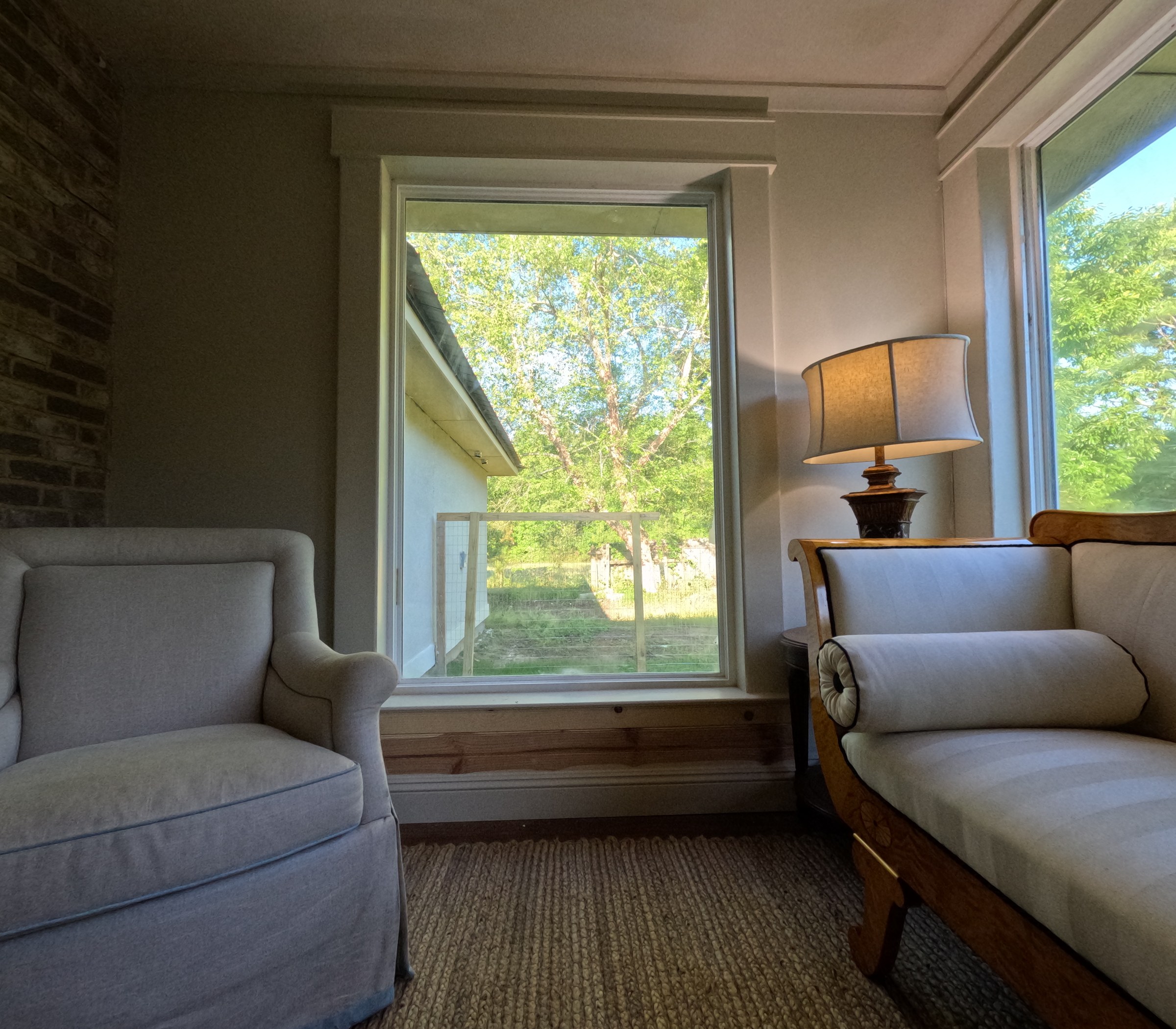 Sunroom window with painted casing landing on a wide wood si Sunroom window with painted casing landing on a wide wood sill and apron, over a tongue-and-groove base
