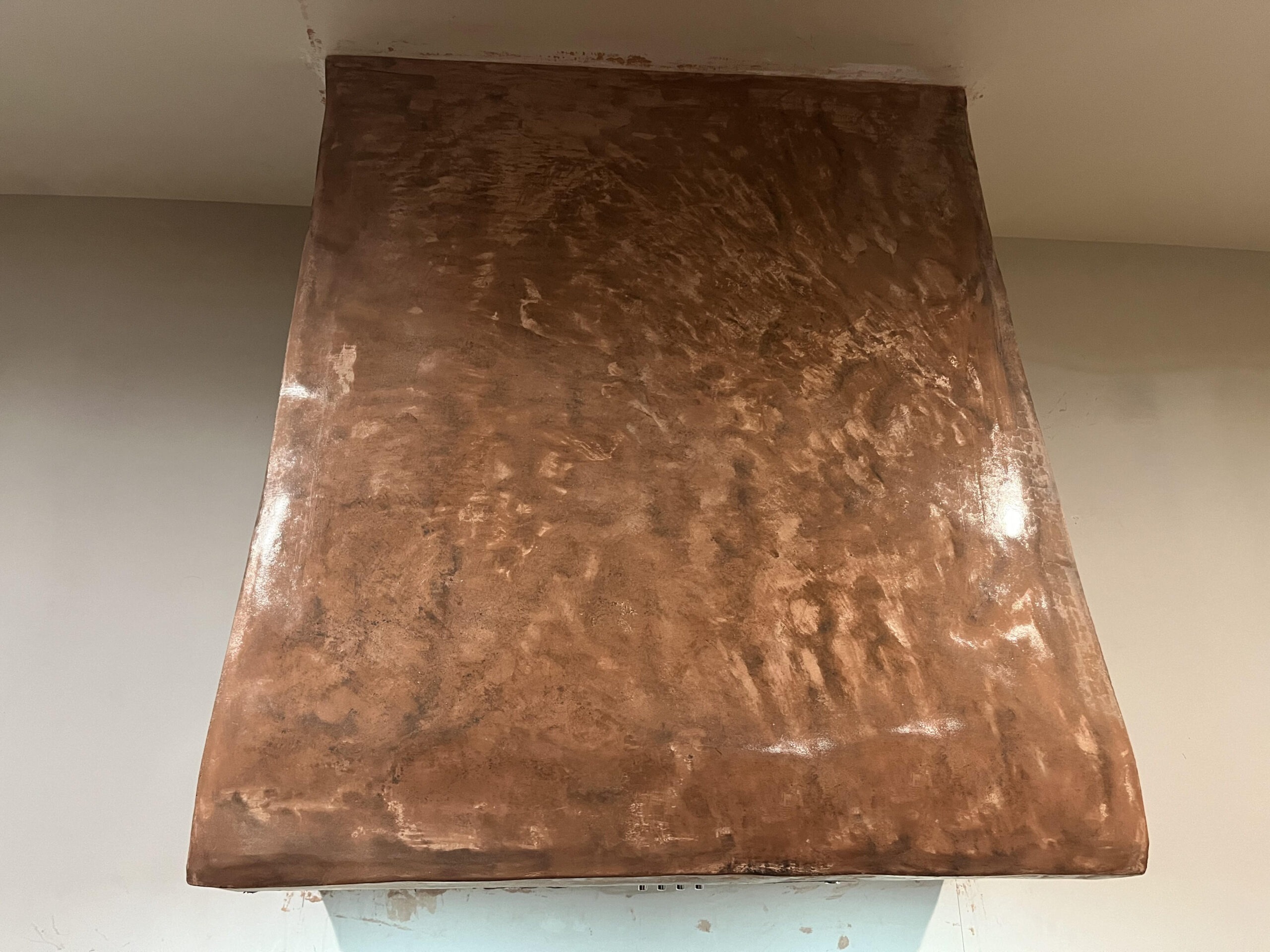 Close-up of a range hood finished in tadelakt, troweled with a swirling motion