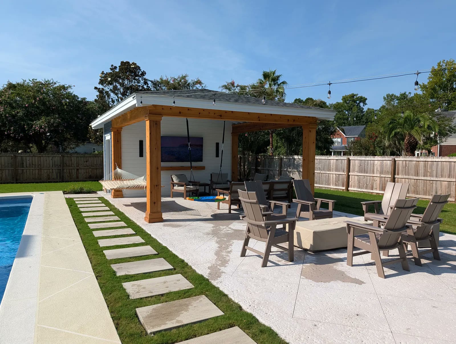 Covered cabana with cedar posts and beams, a white shiplap wall with a mounted TV, and a hammock