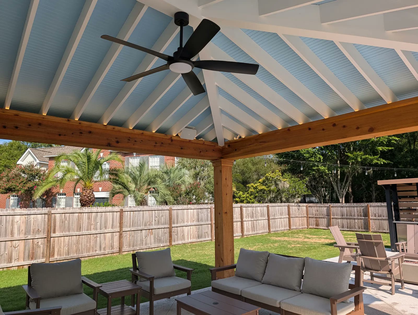 Vaulted cabana ceiling painted haint blue with white rafters, cedar beams and a ceiling fan